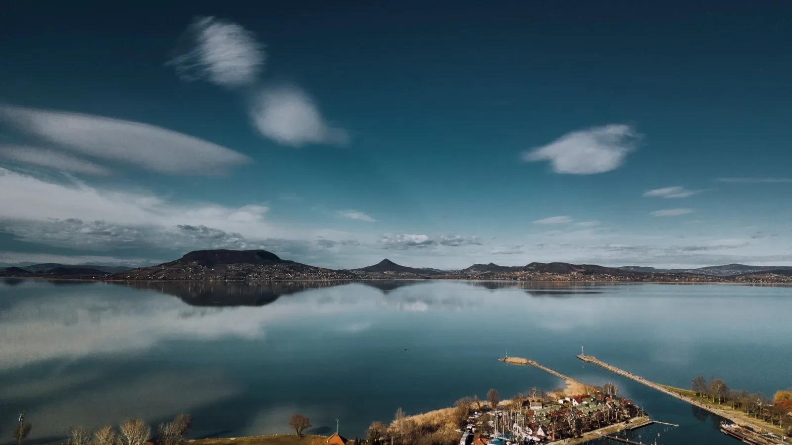Breathtaking aerial view of Lake Balaton reflecting mountains at twilight, capturing Hunga