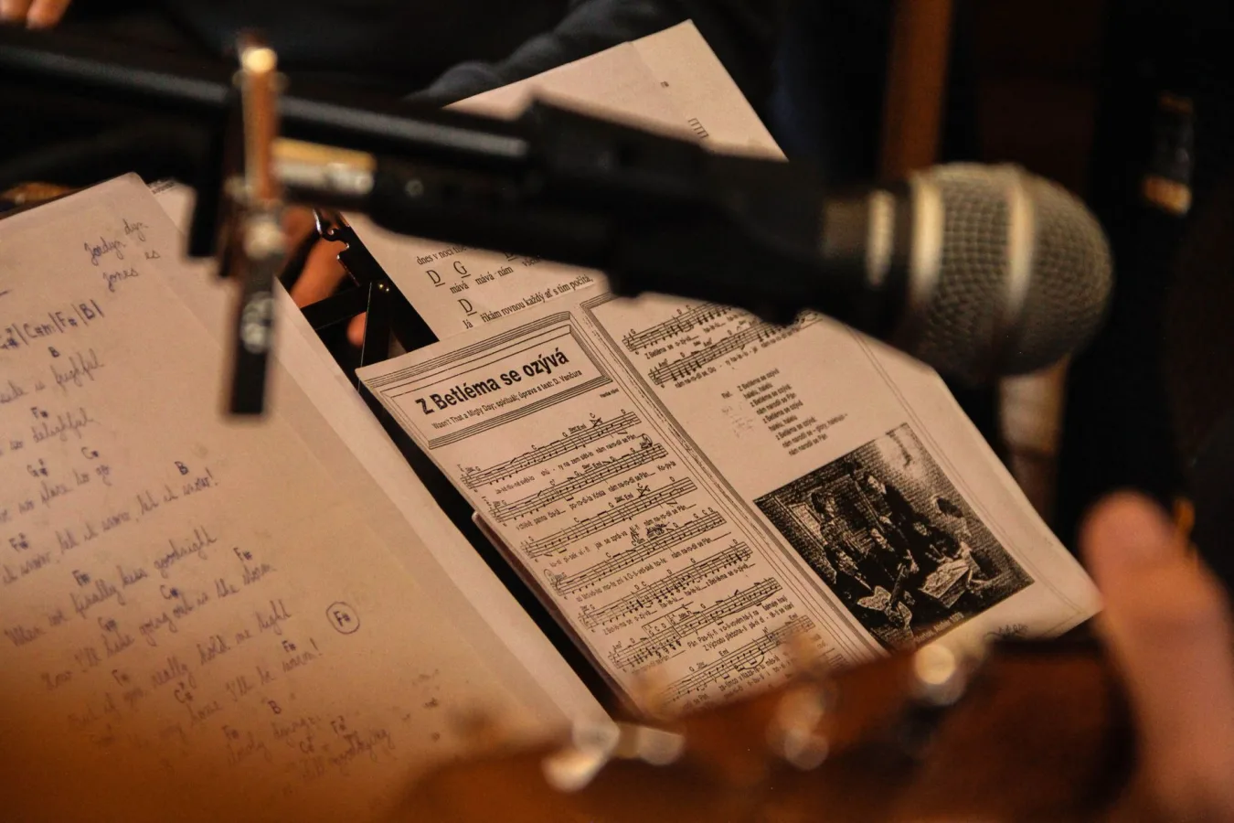 Close-up of sheet music with a microphone in a performance setting, capturing a musical mo
