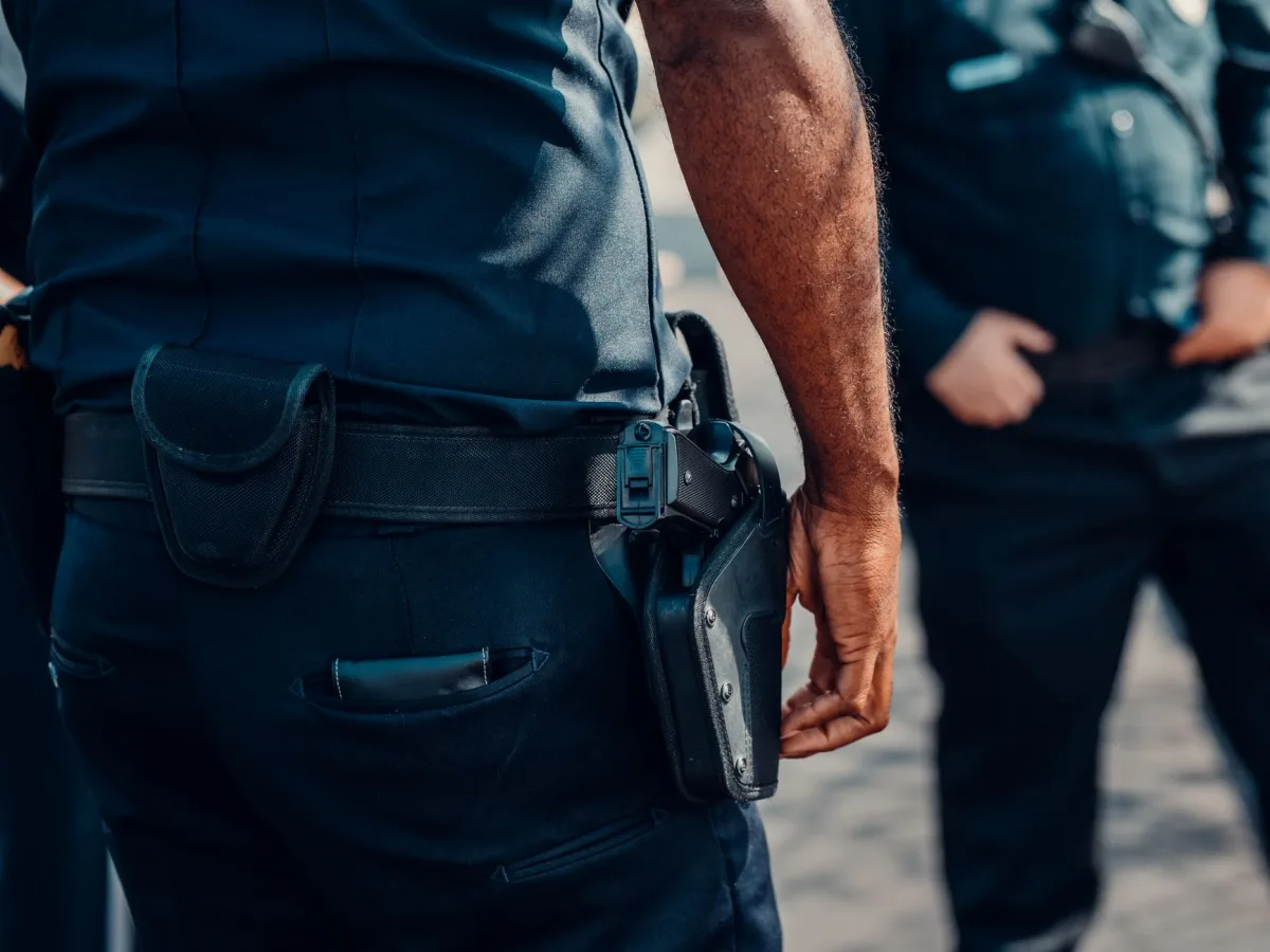 Close-up of a police officer's firearm securely holstered at the waist, conveying professi