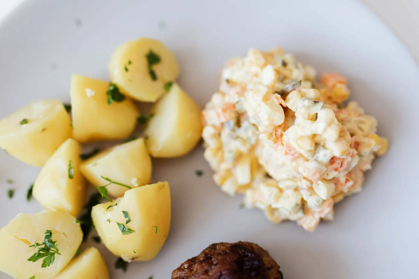 From above plate with boiled potatoes with parsley and portion of tasty nutritious Russian