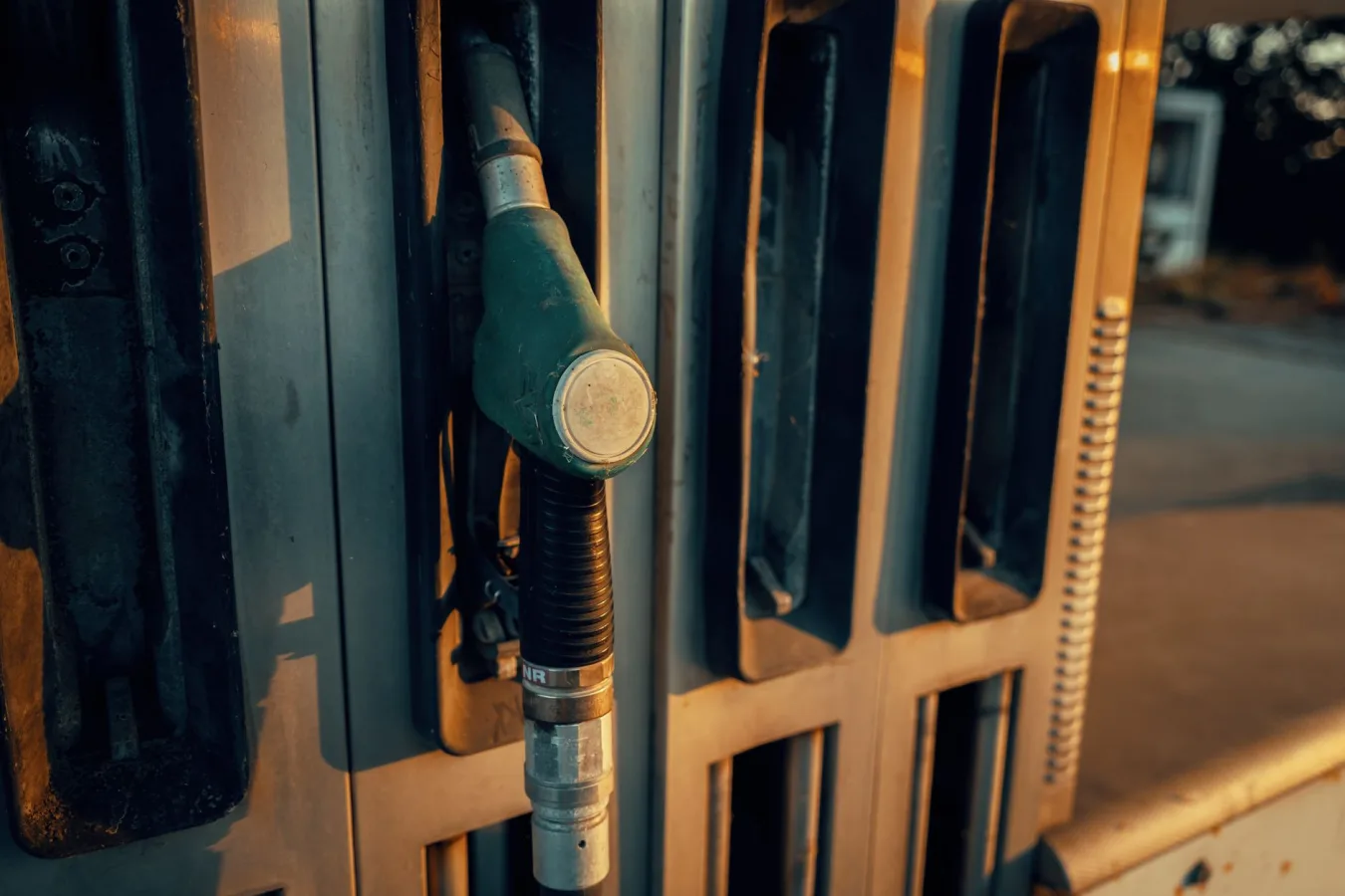 A detailed view of a gas pump nozzle during sunset in Österreich, highlighting industrial