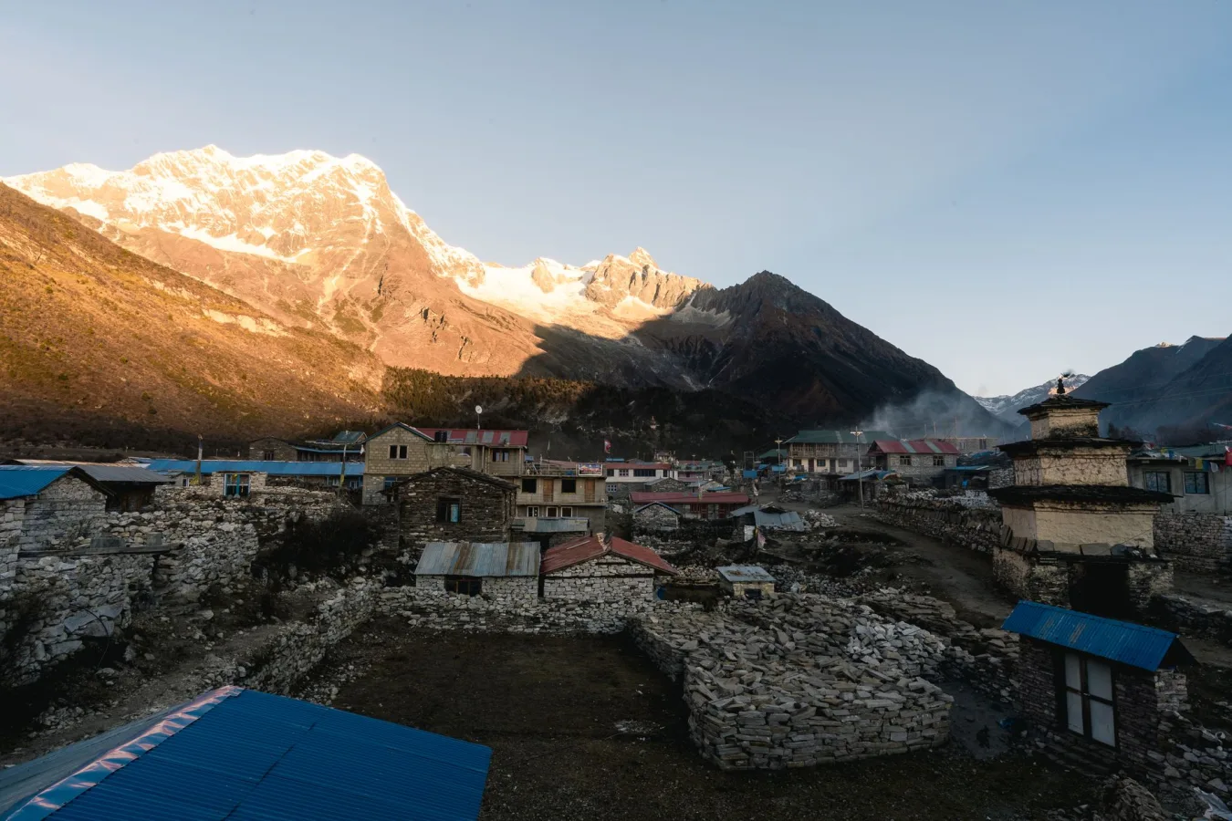 A serene Himalayan village with mountains at sunrise, showcasing rustic architecture in Ne
