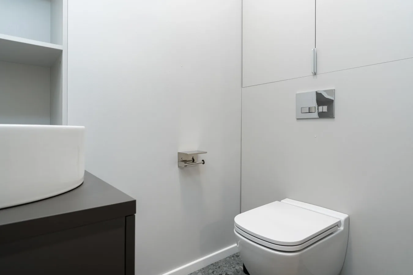 Sleek minimal bathroom showcasing a modern wall-mounted toilet and basin.