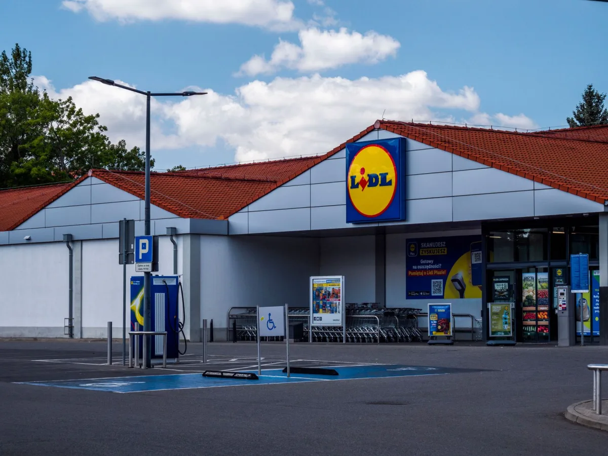 Lidl supermarket exterior featuring parking area and shopping carts on a sunny day.